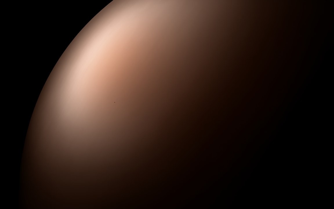 The smooth, hazy salmon-pink face of a planet filling most of the frame, an impression of GJ 1214 b.